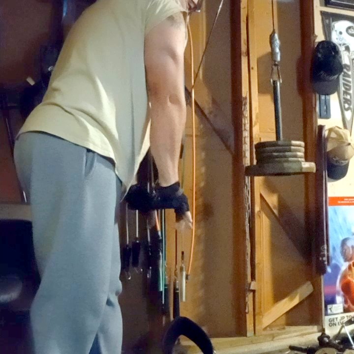Mid-workout in the garage gym, setting up a cable exercise